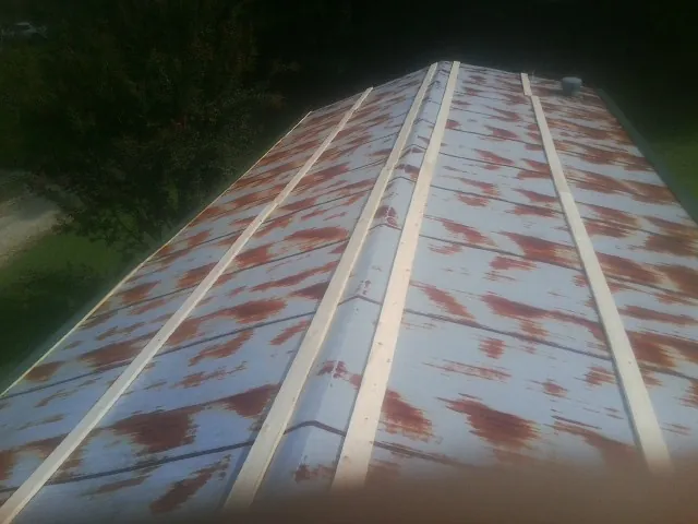Rusted metal roof panels with new wood purlins before replacement — Storm Damage Roof Repair in Swainsboro by Roofing Brothers