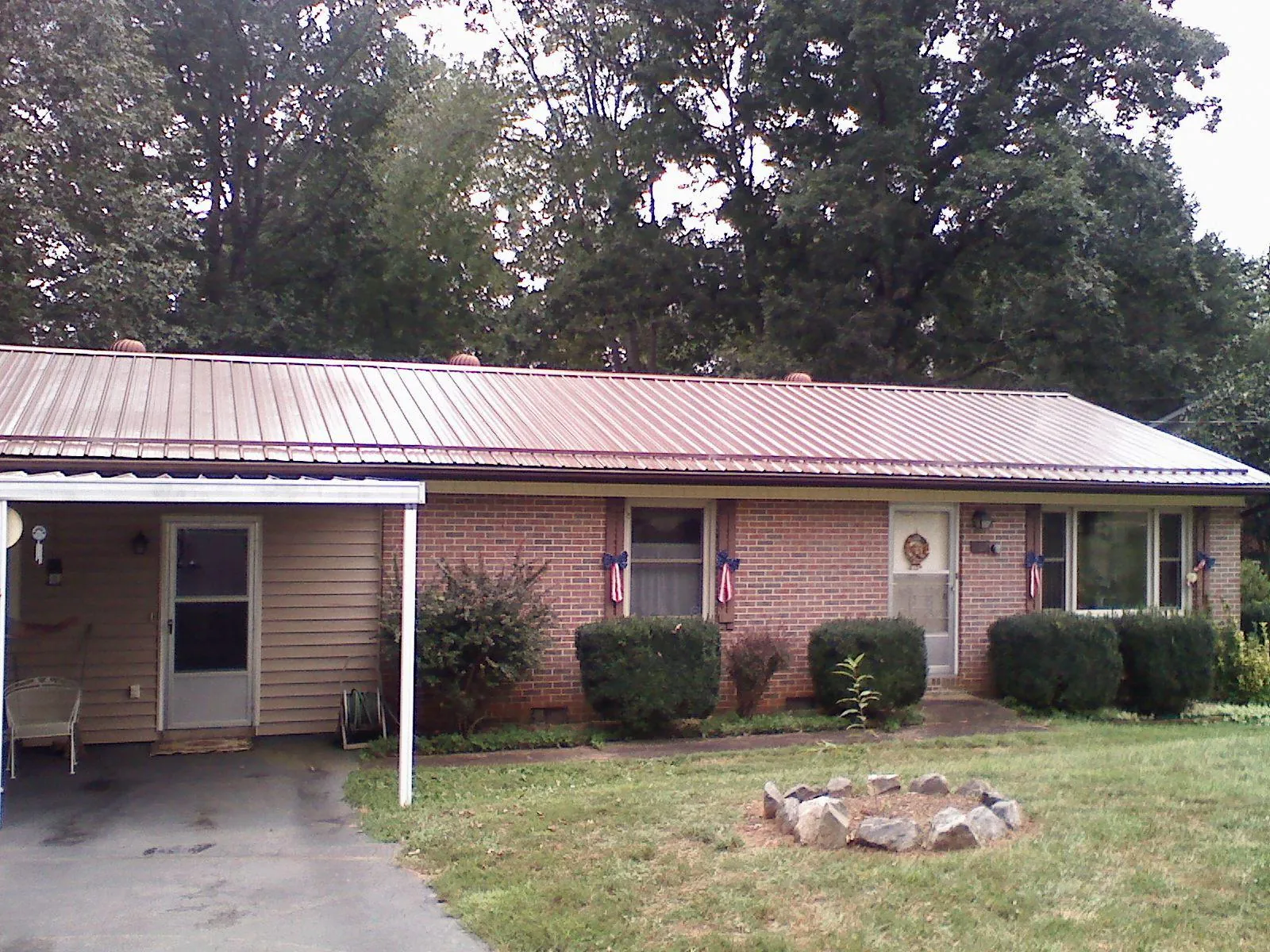 Bronze metal roof and carport on a brick ranch home — Roof Repair work by our crew in Swainsboro